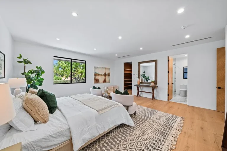 Primary bedroom suite with wide-plank flooring and garden glazing